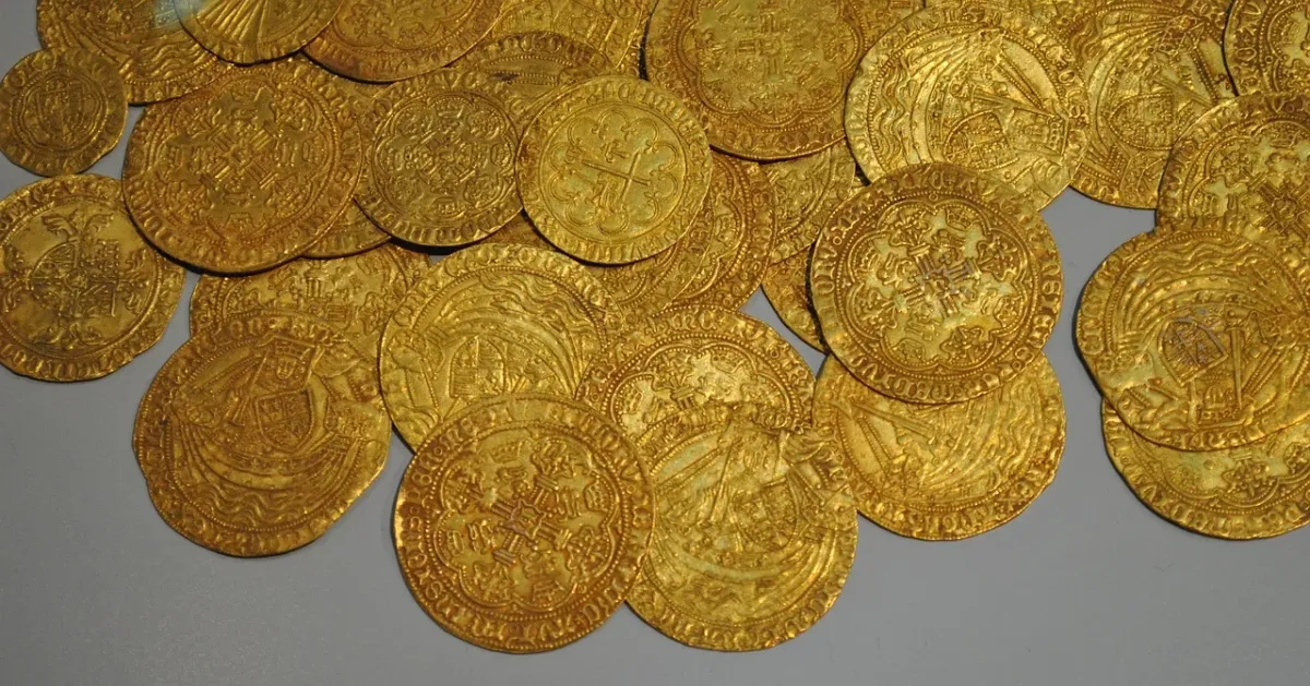 Złota moneta Krugerrand na aksamitnym tle, symbolizująca inwestycję w kruszce i budowanie kapitału.